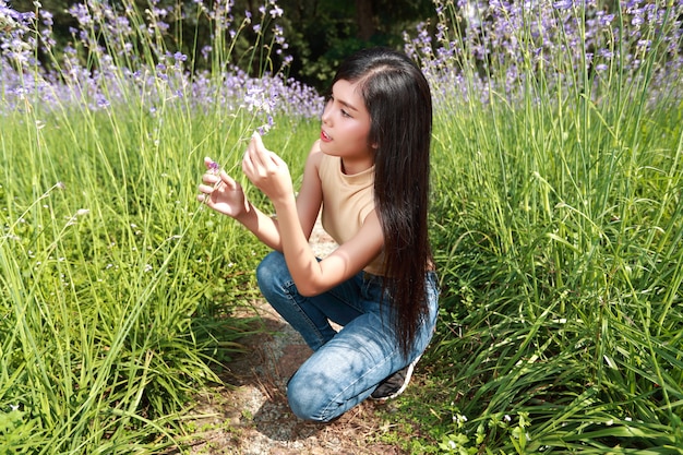 Портрет красивой женщины, имеющие счастливое время и наслаждаясь среди цветов Нага-хохлатая поля в природе