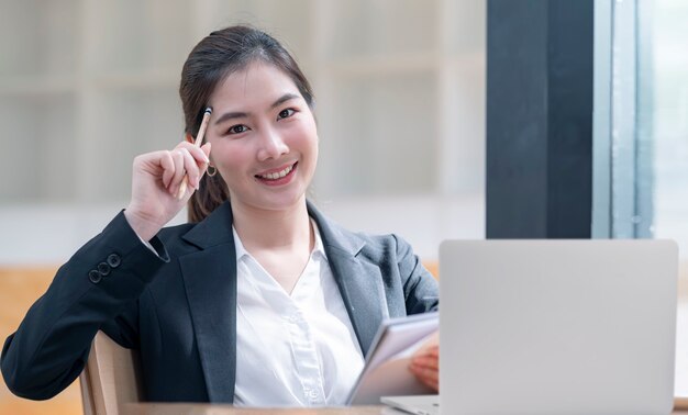 Portrait of beautiful woman hold pencil touch her head, smiling and looking at camera