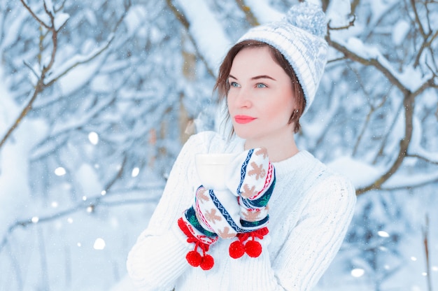 Foto ritratto di una bella donna che tiene una tazza di tè nelle sue mani.