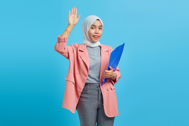 Portrait of a beautiful woman holding a folder against on blue background