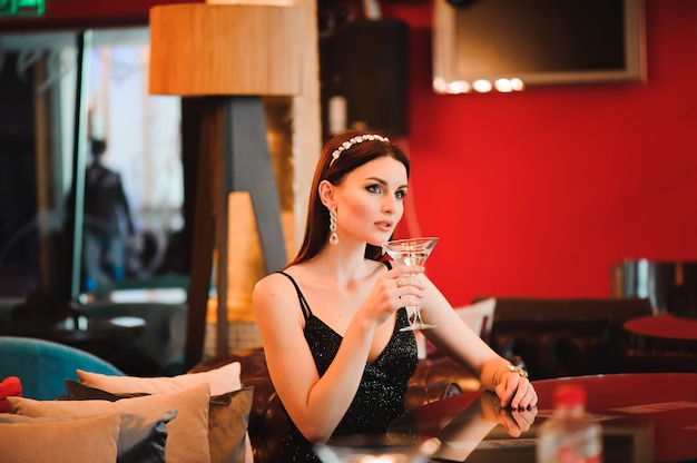 Portrait of beautiful woman holding glass of martini.