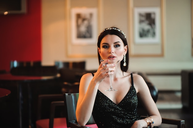 Portrait of beautiful woman holding glass of martini