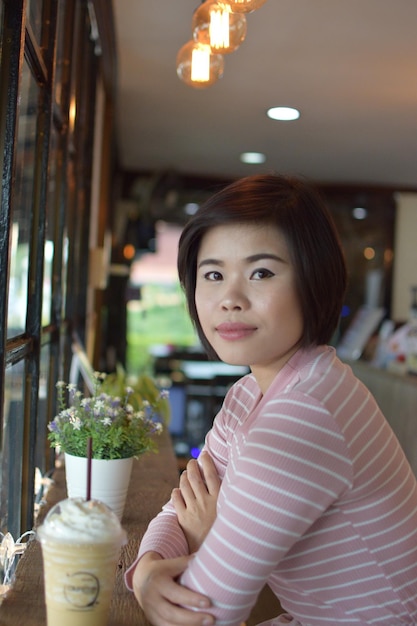 Photo portrait of beautiful woman holding indoors