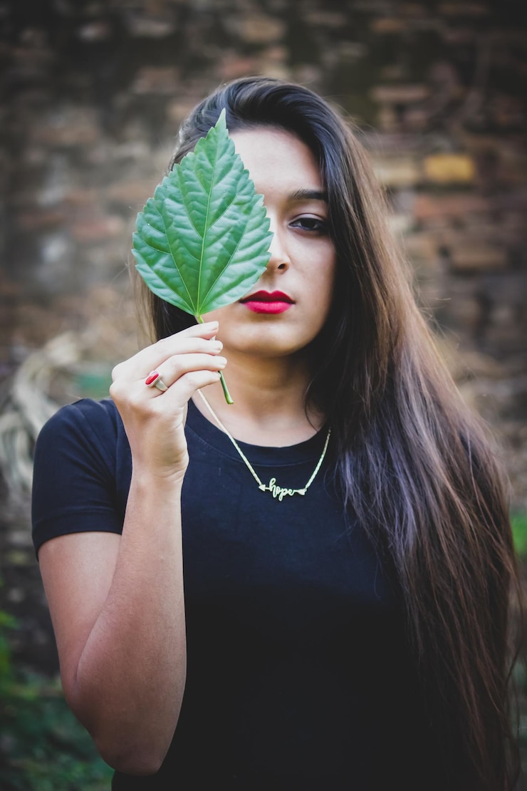 फोटो portrait of beautiful woman holding leaves outdoors