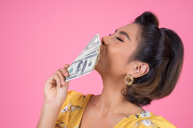 Portrait of beautiful woman holding pink face against gray background