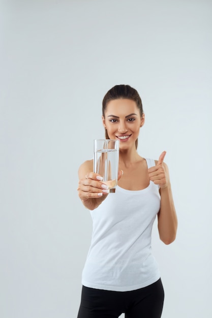 Foto il ritratto di bella donna tiene il bicchiere d'acqua. bere acqua. ragazza con un bicchiere d'acqua. concetto di dieta