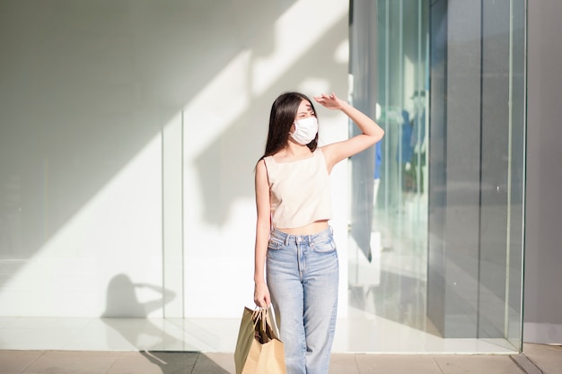 Portrait of beautiful woman is wearing face mask in shopping center