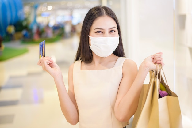 Portrait of beautiful woman is wearing face mask in shopping center