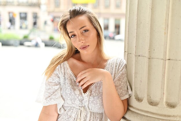 Portrait of beautiful woman leaning on koble wall