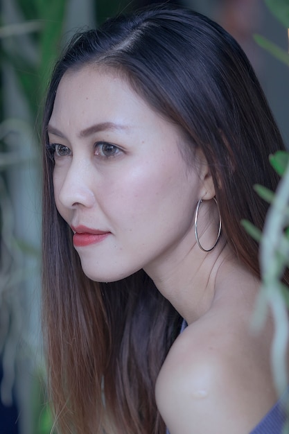 Portrait of a beautiful woman under the leaves looking