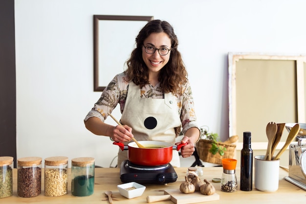 Portrait of beautiful woman looking at camera while cooking in an organic store.