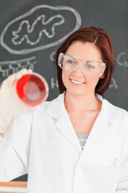 Portrait of a beautiful woman looking at a petri dish