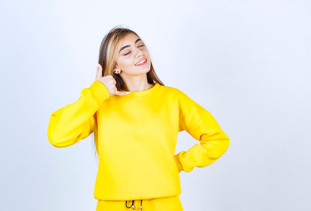 Portrait of beautiful woman model making phone call gesture