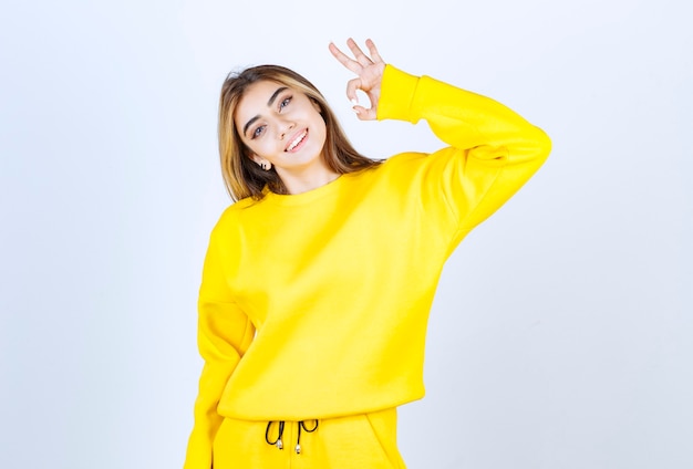 Portrait of beautiful woman model standing and doing ok gesture