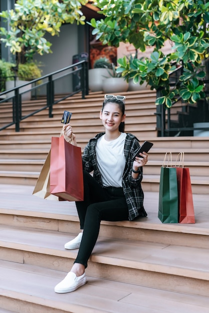 Portrait beautiful woman place eyeglasses on head holding shopping bag