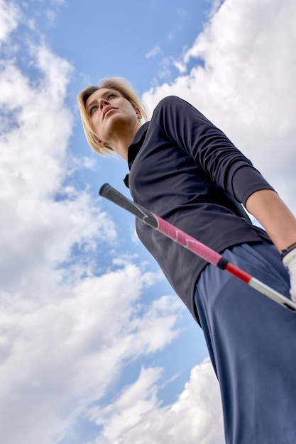 Портрет красивой женщины, играющей в гольф на зеленом поле на открытом воздухе. Концепция гольфа: стремление к совершенству, личное мастерство, королевский спорт.