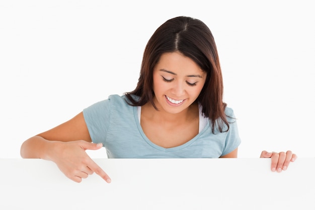 Portrait of a beautiful woman pointing at a board