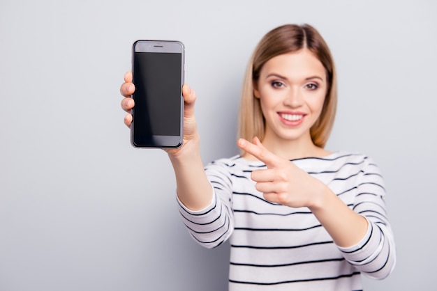 Portrait of beautiful woman pointing at smartphone