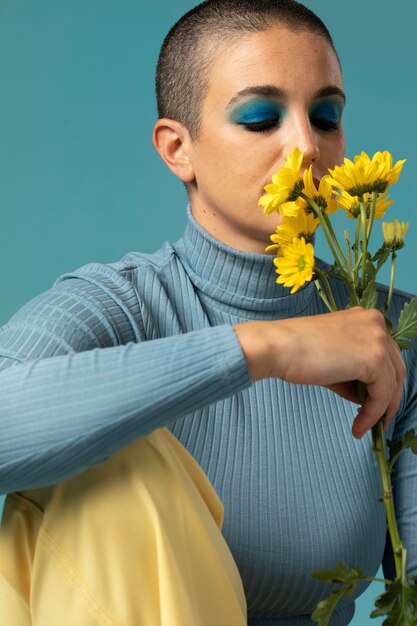 Ritratto di bella donna che posa in un dolcevita con fiori gialli