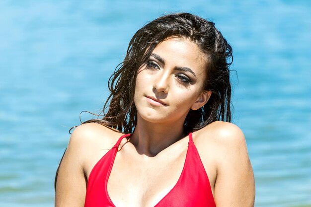 Portrait of a beautiful woman in red bikini on the beach