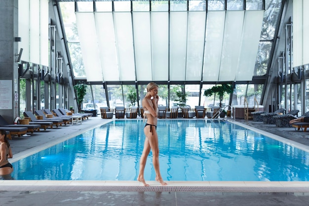 Портрет красивой женщины, расслабляющейся и наслаждающейся в бассейне