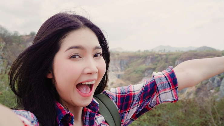 Photo 空に照らされた山の上に立って叫んでいる美しい女性の肖像画