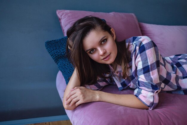 Portrait of beautiful woman in sexy stylish lingerie and plaid shirt model with perfect sensual figure pose in home interior morning in bedroom the idea and concept of pleasant leisure at home