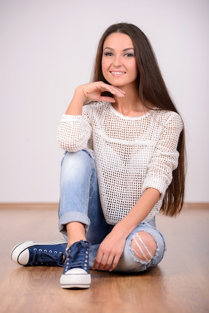 Portrait of beautiful woman sitting on the floor.