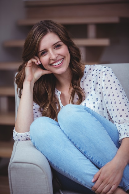 Portrait of beautiful woman sitting on sofa