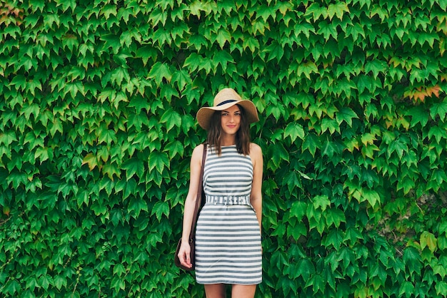 Portrait beautiful woman smiling in front of wall of ivy plants on summer vacation. Portrait beautiful woman smiling in front of wall of ivy plants on summer vacation.