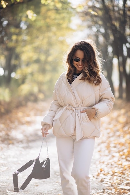 Portrait of beautiful woman smiling and walking in park