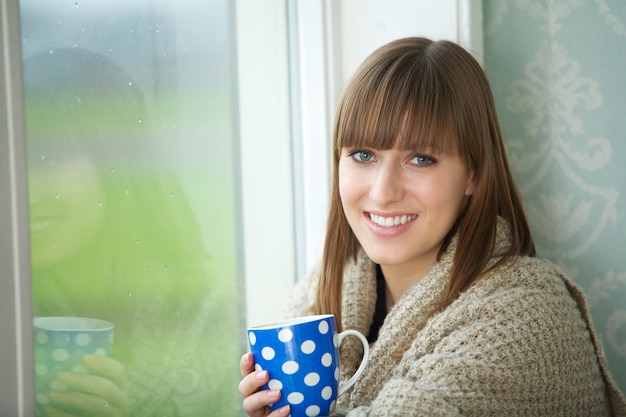 Portrait of a beautiful woman smiling with cup of tea