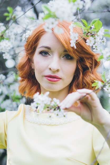 Portrait of beautiful woman in spring blooming garden