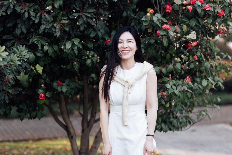 Photo 花を ⁇ かせている植物の前に立っている美しい女性の肖像画