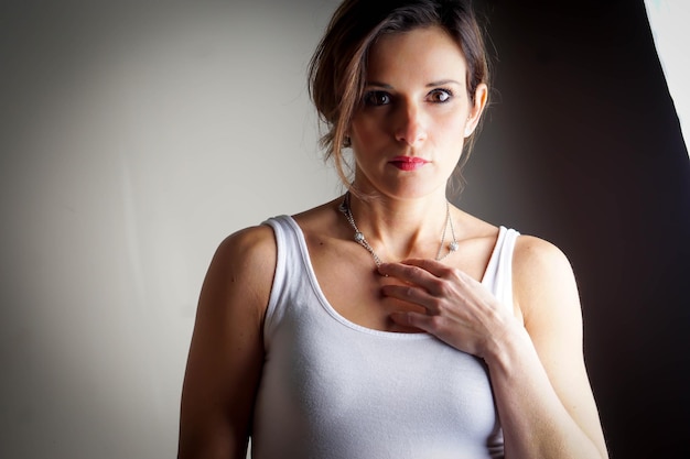 Portrait of beautiful woman standing against gray background