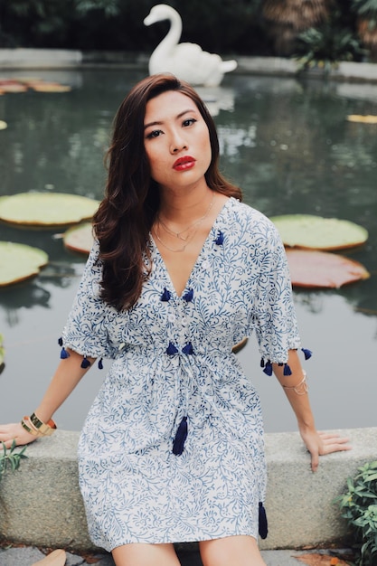 Portrait of beautiful woman standing against lake