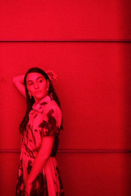 Photo portrait of beautiful woman standing against red wall