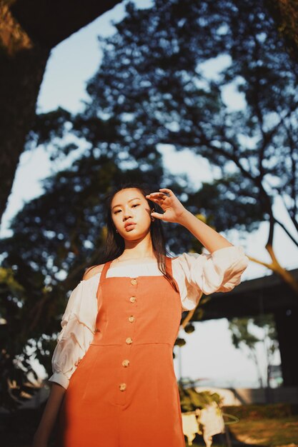 Portrait of beautiful woman standing against tree