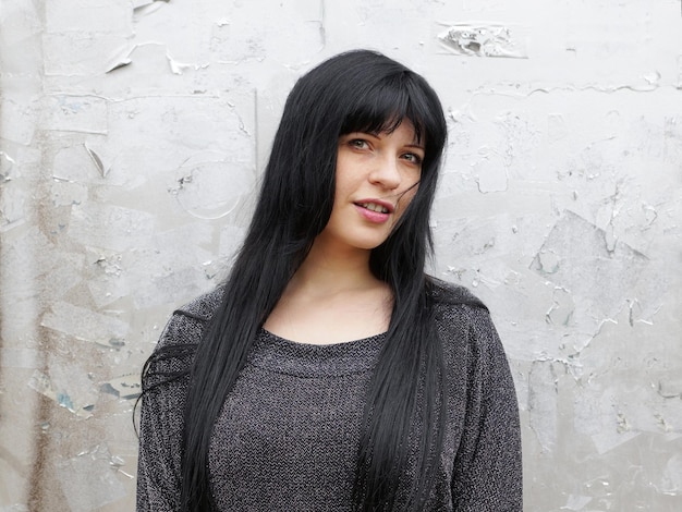 Photo portrait of beautiful woman standing against weathered wall