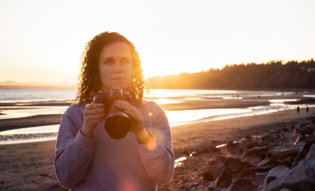Photo portrait of beautiful woman standing on beach against sky during sunset