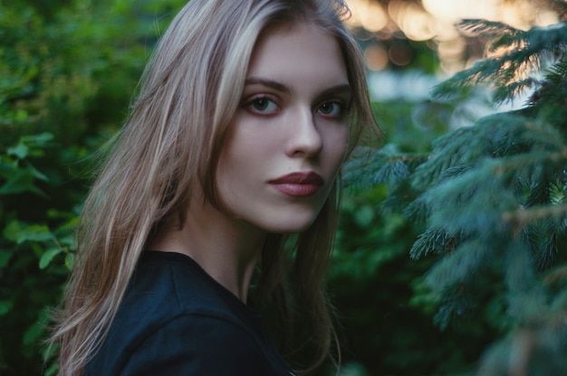 Portrait of beautiful woman standing by plant