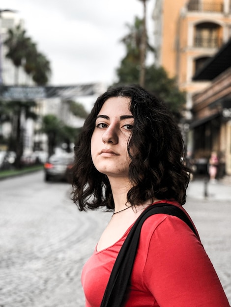 Portrait of beautiful woman standing on road in city