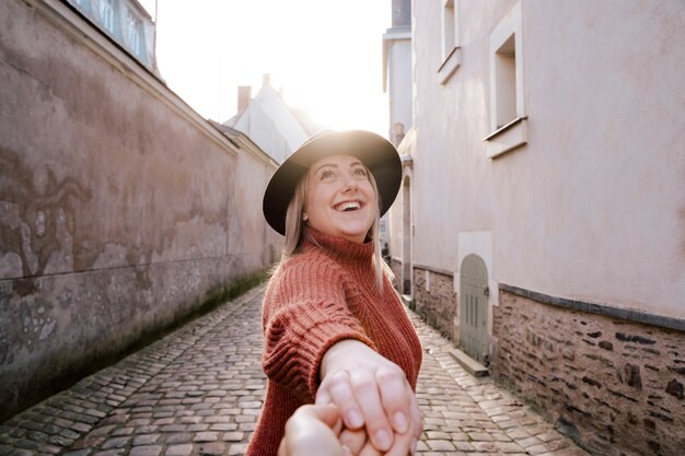 Portrait of beautiful woman standing in the street outdoors holding someone's hand