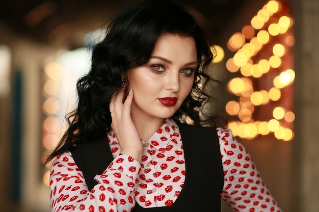 Portrait of a beautiful woman on the street with a background of blurred lights bulbs