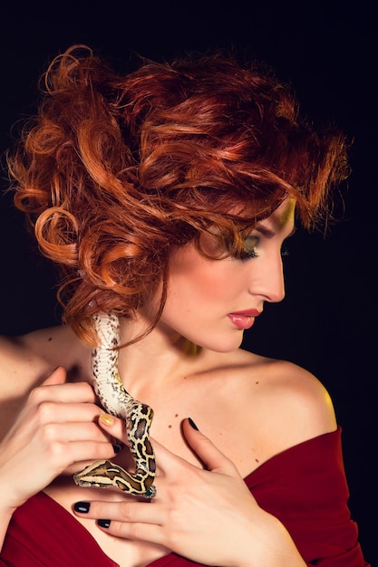 Portrait of Beautiful Woman in studio with dangerous snake