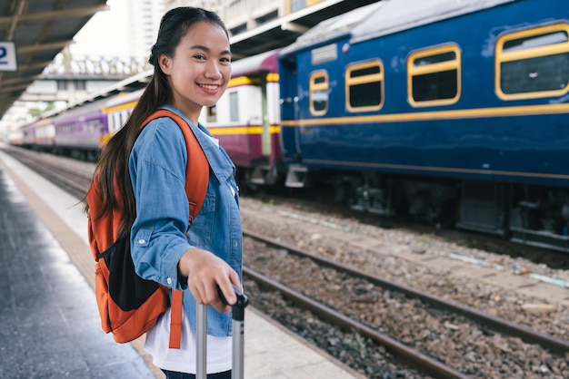 駅でバッグパックと肖像画の美しい女性旅行者観光客