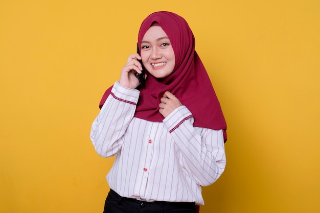 Portrait of beautiful woman wearing hijab talking with a phone gazes smile and fun expression