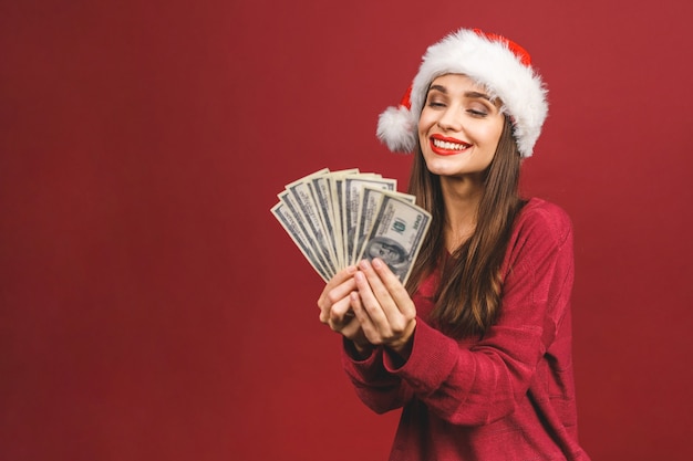 Ritratto di bella donna che indossa il cappello della santa e che tiene le banconote del dollaro