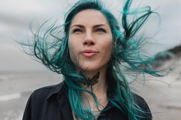 Портрет красивой женщины с голубыми волосами, развевающимися на ветру