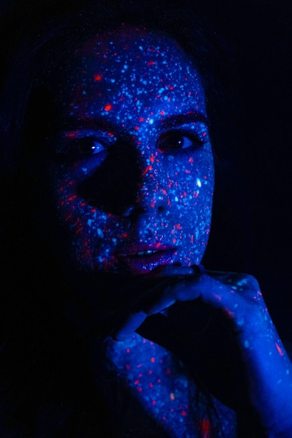 Portrait of a beautiful woman with blue sequins on her face Girl with artistic makeup in Light color Fashion model with colorful makeup